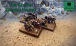 A group of Zayken miniatures representing a horde of zombies is displayed on two textured bases, set against a rocky backdrop. The zombies exhibit various poses, with some appearing hunched and others reaching forward, showcasing their grotesque features and tattered clothing. The scene is set on a sandy terrain, with scattered rocks and sparse vegetation, emphasizing the desolate environment of the sci-fi wargame.