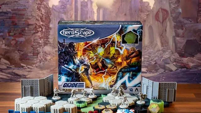 A G.I. JOE Heroscape: Rumble at the Rift Battle Box is prominently displayed in the center, featuring vibrant artwork of characters in action. Surrounding the box are various game components, including eight miniatures representing characters like Duke and COBRA Commander, modular hex terrain pieces, COBRA fortifications, dice, and markers. The background features a blurred, crumbling environment, enhancing the game's adventurous theme.