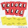 Five red cards with white and gold text spelling "PRIORITIES" in sections. Five yellow cards with names: "Nesta," "Middengard Wyrm," "Spring Court," "The Nightmare Court," and "Lucien’s Golden Eye."
