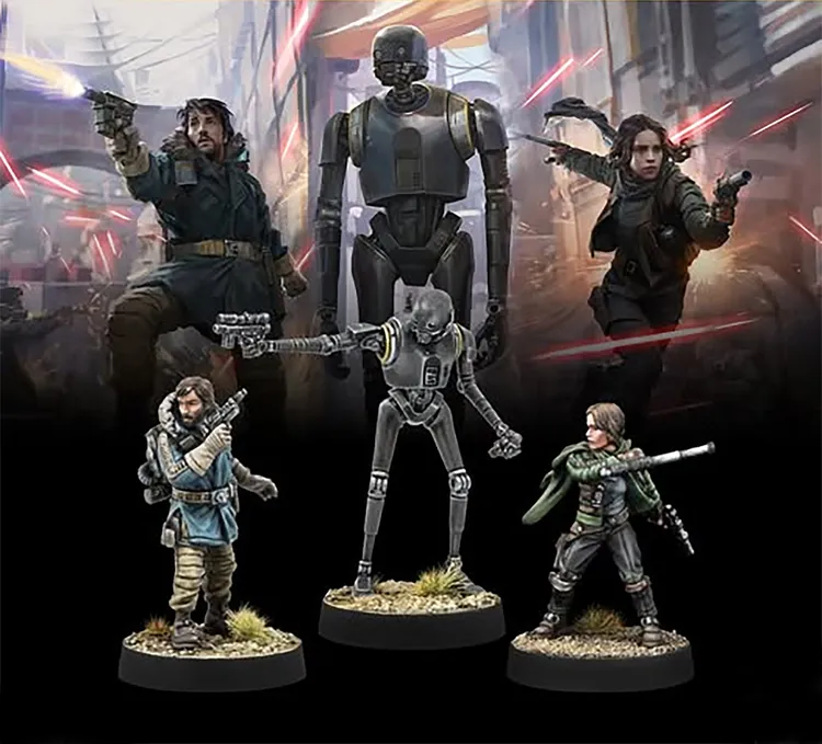 A dynamic scene features four miniatures from the Star Wars universe, prominently displayed against a backdrop of a chaotic urban environment with red laser blasts. The miniatures include Cassian Andor and Jyn Erso, both armed and in action poses, alongside the droid K-2SO, which stands tall and imposing. In the foreground, a fourth character, also armed, is depicted in a more relaxed stance, adding to the ensemble of this Rebel team.