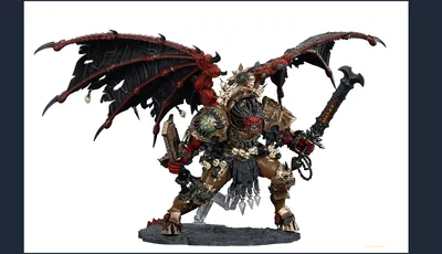 A large, intricately detailed statue of Angron, the Daemon Primarch of Khorne, stands prominently. He features massive, bat-like wings and a fierce expression, with a head that appears relatively small compared to his muscular body. Adorned with skulls and ornate armor, he wields a large sword in one hand and a weapon in the other, standing on a textured base that enhances the dramatic effect of the figure. The color palette includes deep reds, blacks, and metallic tones, emphasizing his menacing presence.