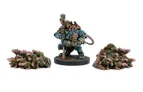 A detailed miniature of a Verr-Myn character stands prominently in the center, clad in blue armor with a large, menacing head resembling a rat. The character holds a staff and has a tail extending behind it. Flanking the main figure are two piles of smaller, rat-like creatures, depicted in various shades of brown and green, suggesting a swarm ready to engage in battle. The base is textured to resemble a rugged terrain, enhancing the overall dynamic of the scene.