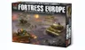 A box for the "Fortress Europe" starter set for the Flames Of War wargame prominently displays the title in bold, distressed lettering. The artwork features a dynamic battlefield scene with American and German forces, including tanks and soldiers engaged in combat. The background showcases a smoky, war-torn landscape, enhancing the theme of World War II wargaming.