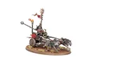 A chariot pulled by two fierce-looking wolves features a pair of goblin riders, one wielding a weapon and the other holding reins. The chariot is adorned with flames and a banner, set against a base with scattered grass and skulls. The overall color scheme includes earthy tones with vibrant accents, emphasizing the chaotic nature of the goblin faction.