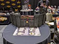 Model of Castle Ravenloft with miniatures on a map, WizKids banners in background.