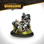 A trio of trollkin figures from the Southern Kriels Kithguard army is depicted, with two standing beside a mortar. One trollkin, wearing a black vest and holding a mortar tube, has blue skin adorned with red spots. The other, with a more robust build, is positioned to the left, gripping a lever on the mortar. The base features tufts of green grass, enhancing the scene's dynamic feel.