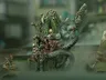 Green-skinned monster with long hair, horns, and a staff, holding a severed head.