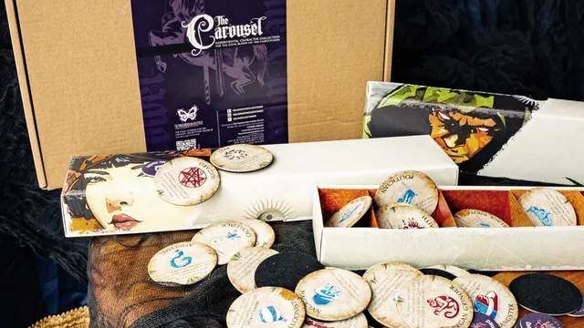 Open box of The Carousel with circular character tokens and a purple booklet.