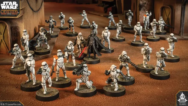 A group of Star Wars miniatures features several Stormtroopers in white armor, positioned in a desert-like environment with a backdrop of a weathered building. Among them stands a prominent figure in black armor, holding a red lightsaber, likely representing Darth Vader. The scene is detailed with various poses of the troopers, some aiming weapons, while others appear to be in action, all set on circular bases with textured surfaces.