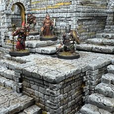 A detailed scene showcases a modular dungeon setup made from intricately sculpted stone blocks, featuring various levels and staircases. Four miniatures are positioned on the blocks: a bearded wizard with a staff, a robed figure holding a spear, and a knight in armor wielding a weapon, all engaged in exploration. The textured stone surfaces and the overall layout highlight the versatility of the dungeon blocks for tabletop gaming.