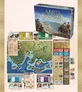 A large board game setup for "Mega Empires: The Far East - North" is displayed, featuring a detailed game board depicting East Asia with various regions marked in different colors. The game box is positioned at the top, showcasing the title and artwork. Surrounding the board are numerous game components, including player boards, trading cards, and tokens, all organized neatly to facilitate gameplay.