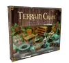 A holiday gift calendar titled "Terrain Crate" is prominently displayed, featuring a wooden background adorned with pinecones and holly. The calendar showcases various miniature terrain pieces, including barrels, crates, a stone well, and a desk, alongside two figures engaged in a fantasy setting. The text on the box indicates it is designed for fantasy dungeon crawlers and role-playing games.