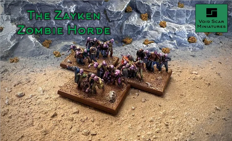 A group of Zayken miniatures representing a horde of zombies is displayed on two textured bases, set against a rocky backdrop. The zombies exhibit various poses, with some appearing hunched and others reaching forward, showcasing their grotesque features and tattered clothing. The scene is set on a sandy terrain, with scattered rocks and sparse vegetation, emphasizing the desolate environment of the sci-fi wargame.