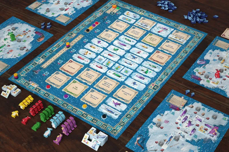A wooden table with multiple game boards featuring a blue and white icy ocean theme. The central board is divided into numbered spaces with illustrated cards placed on them, showing text such as "Gain 1 fish", "Have at least 6 penguins in a family", "Take 1 fish", "Score at least 50 points from fish cards", and "Have at least 5 eggs". The cards display various penguins and fish illustrations. Surrounding the central board are smaller game boards with similar icy ocean themes and penguin illustrations. Colorful plastic pieces in shapes resembling penguins, fish, and ice blocks are scattered around the boards. There are also small round tokens in various colors placed on the boards.