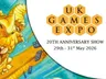 A vibrant illustration features a large, golden dragon with a playful expression, showcasing its sharp teeth and prominent features. The dragon is surrounded by a blue background with scattered game dice, emphasizing a whimsical and dynamic atmosphere. The UK Games Expo logo is prominently displayed in the corner, indicating the event's 20th anniversary from May 29th to 31st, 2026.