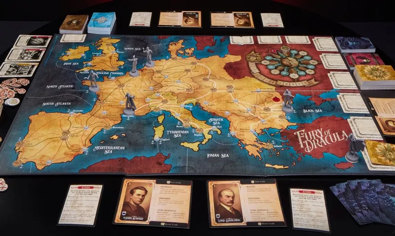A detailed game board of Fury of Dracula: 5th Edition is displayed, featuring a map of Europe with various cities connected by routes. Several miniatures representing characters stand on the board, including hunters positioned in different locations. Below the board, character cards for John Seward and Lord Godalming are visible, along with a set of action cards, enhancing the game's strategic elements. The overall color scheme includes warm earth tones for the land and blue for the surrounding seas.