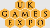 The design features the text "UK GAMES EXPO" arranged in a honeycomb pattern, with each letter placed inside a yellow hexagon. The font is bold and black, creating a strong contrast against the yellow background. The overall layout emphasizes the event's branding in a visually engaging manner.