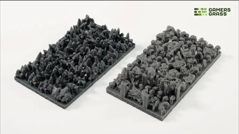 Two rectangular trays filled with gray miniature terrain pieces and scatter elements.
