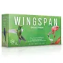 A box for the "Wingspan: Americas Expansion" features a vibrant green background with illustrations of various birds, including a colorful hummingbird on the left and a pink flamingo on the right. The title "WINGS PAN" is prominently displayed in large white letters, with the subtitle "Americas Expansion" below it. Additional text notes the game's design and illustration credits, along with details about player count and age suitability.