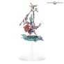 A Greater Daemon of Tzeentch miniature on a small round base. The figure is perched atop a blue, tentacle-like creature, holding a staff with a golden, serpentine top. The daemon has pink and purple skin, intricate golden armor, and a horned head with glowing eyes.
