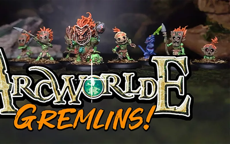 Three distinctive Gremlin miniatures are prominently displayed against a dark, forested background. The first Gremlin on the left has a wooden mask-like face and vibrant green skin, while the central Gremlin features a fierce expression with a large, toothy grin and a decorative necklace. The third Gremlin on the right holds a weapon and has a playful stance, showcasing the whimsical design typical of the ArcWorlde faction. The text "ArcWorlde GREMLINS!" is boldly featured at the bottom, emphasizing the campaign's focus.