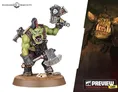 A green-skinned Ork miniature stands confidently, wielding a large axe in one hand and a gun in the other. The Ork has a fierce expression, with a prominent underbite and a mohawk hairstyle, dressed in rugged armor and a utility belt. The base is textured with dirt and a small skull, emphasizing the gritty aesthetic typical of the Warhammer 40,000 universe.