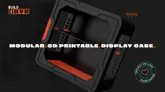 A sleek, 3D-printable display case designed for collectors, featuring a black exterior with angular lines and a vibrant red base. The case is shown from a slightly elevated angle, highlighting its modular design and snap-fit assembly, which requires no tools. The text "3D-PRINTABLE. DISPLAY CASE." is prominently displayed, along with a "PROJECT WE LOVE" badge from Kickstarter.
