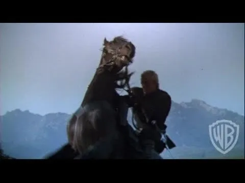 A man on a horse with mountains in the background.
