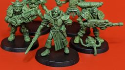 A group of five 28mm scale sci-fi miniatures is displayed against a bright red background. The figures include a Space Commando wielding a rifle, a Starchild with a distinctive helmet, an Assault Goar holding a sword, a Space Orc with a large gun, and a Voidborn equipped with various gadgets. Each miniature features intricate details and a classic old-school aesthetic, showcasing the unique character and charm of the RT Adventurer Pack II from Satyr Art Studios.