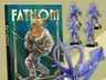 Fathom game box, diver in suit, octopus model, and miniatures.