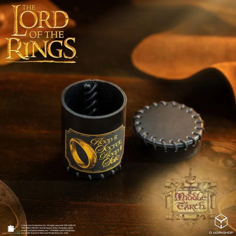 Black leather dice cup with gold ring logo and text "Keep it Secret, Keep it Safe", lid beside it.