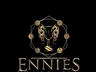 Gold-colored logo on a black background. The logo features a stylized shield with a decorative border. At the center of the shield is a goblet flanked by two dragon-like creatures with wings spread. Surrounding the shield are six circular medallions, each containing a different symbol: a six-sided die showing a 12, a flame, a stylized eye, a sword crossed with a scroll, a gear, and a triangle with a line through it.

Below the shield, the text reads:
"ENNIES
Celebrating Excellence in Tabletop
Role-Playing Games
Since 2001"